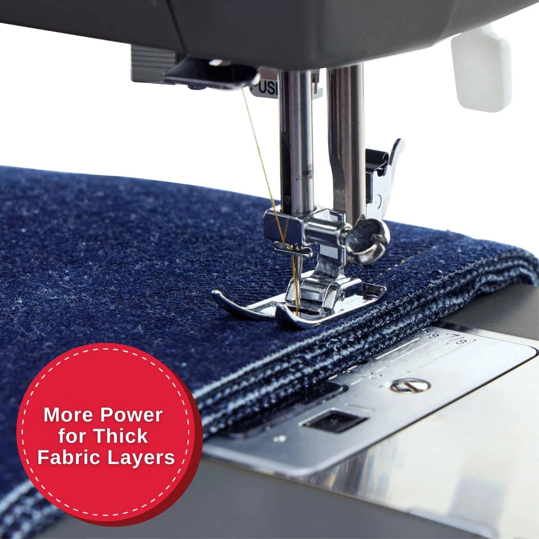 Primer plano de la máquina de coser Singer Heavy Duty 4411 cosiendo una tela azul gruesa.